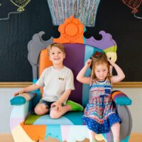 Two children sitting in the Museum's Birthday Throne!